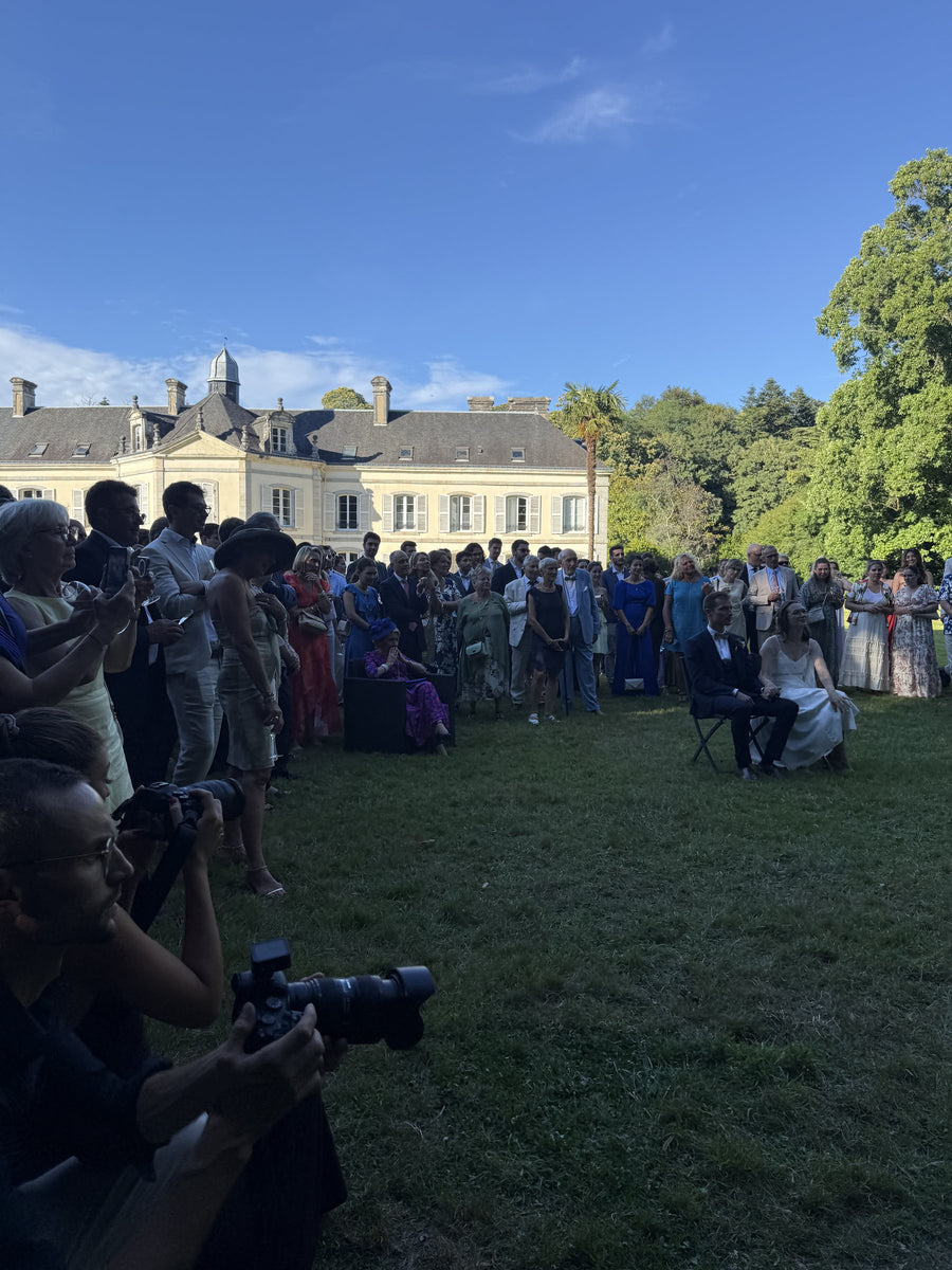 Invités réunis dans le parc d'un château pour une cérémonie