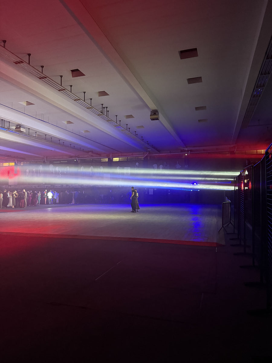 Faisceaux lumineux bleus, blancs et rouges dans une grande salle